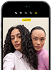 جهاز iPhone&nbsp;18&nbsp;Pro، بلون أسود، الجهة الخارجية الأمامية، عارضتان تتخذان وضعية التصوير أمام الكاميرا، استعراضاً لكاميرا Center&nbsp;Stage الأمامية